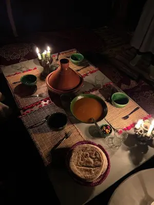 a table with a pot of soup and a bowl of food at Camp Nuyum in Ksiba