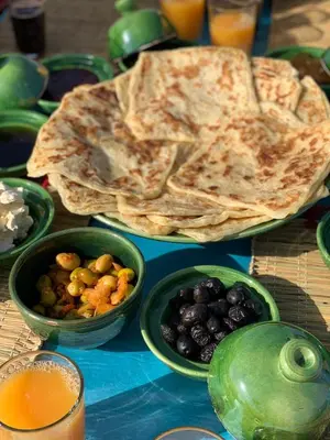 a table topped with green bowls of fruit and sidx sidx sidx sidx sidx at Camp Nuyum in Ksiba