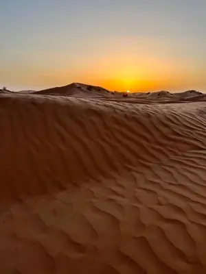 a sunset over the sand dunes in the desert at Camp Nuyum in Ksiba