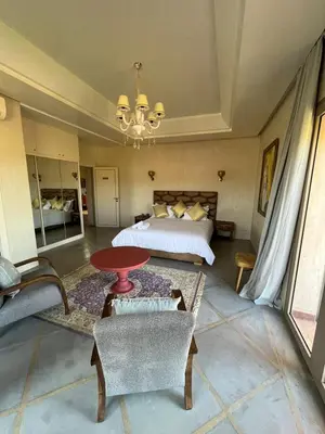 a bedroom with a bed and a table and chairs at VIilla SOLANA Domaine LAMRAH in Oulad Snaguia