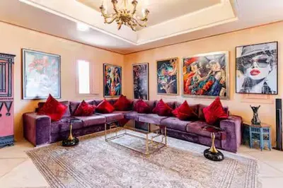 a living room with a purple couch with red pillows at VIilla SOLANA Domaine LAMRAH in Oulad Snaguia