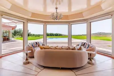 a large living room with a white couch and windows at VIilla SOLANA Domaine LAMRAH in Oulad Snaguia