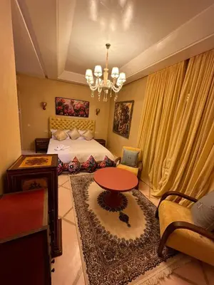 a bedroom with a bed and a table and a chandelier at VIilla SOLANA Domaine LAMRAH in Oulad Snaguia