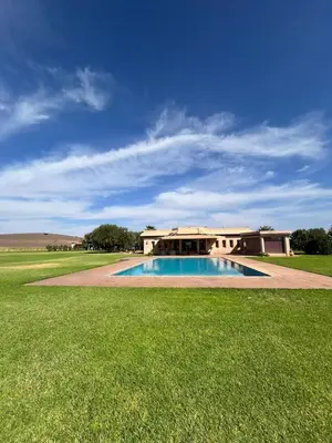 a large house with a swimming pool in the grass at VIilla SOLANA Domaine LAMRAH in Oulad Snaguia