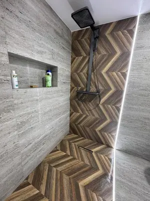 a bathroom with wooden flooring and a stone wall at Meknes Relax Home in Meknès