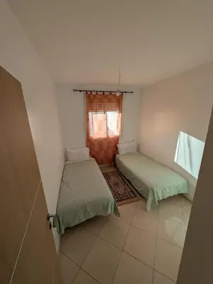two beds in a small room with a window at Apartment in Agadir in Oulad Akkou