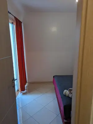a room with a blue couch and a red curtain at Apartment in Agadir in Oulad Akkou