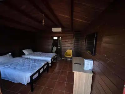 a room with two beds and a yellow chair at Auberge RAMZ'S in Beni Mellal