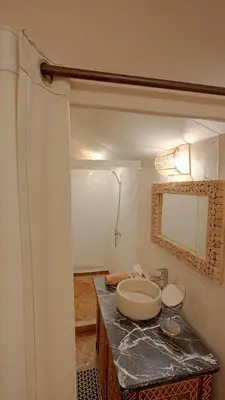 a bathroom with a sink and a mirror on a counter at Merzouga Desert Camping in Hassilabied