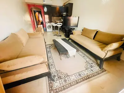 a living room with a couch and a table at Comfortable Apartment with Pool in Oulad Akkou
