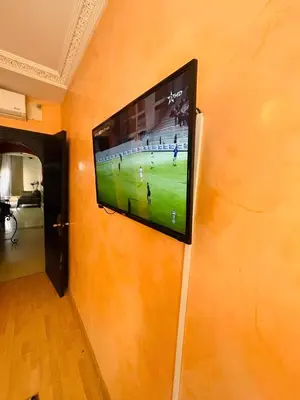 a flat screen tv hanging on a wall at Comfortable Apartment with Pool in Oulad Akkou