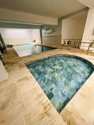 a swimming pool in a building with a pool at Comfortable Apartment with Pool in Oulad Akkou
