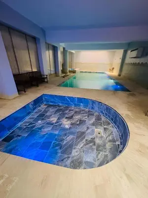 a large swimming pool with blue tiles on the floor at Comfortable Apartment with Pool in Oulad Akkou