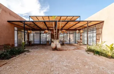 an outdoor patio with a large building with windows at villa Bohème Chic in Had Abdallah Rhiat