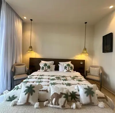 a bedroom with a large bed and two chairs at villa Bohème Chic in Had Abdallah Rhiat