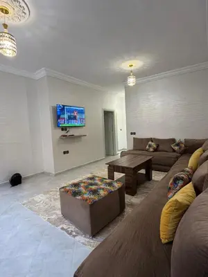 a living room with a couch and a table at Appartement équipé