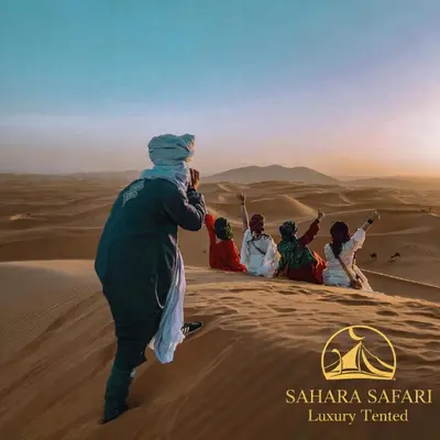 a group of people standing in the desert at Sahara Safari Luxury Tented in Merzouga