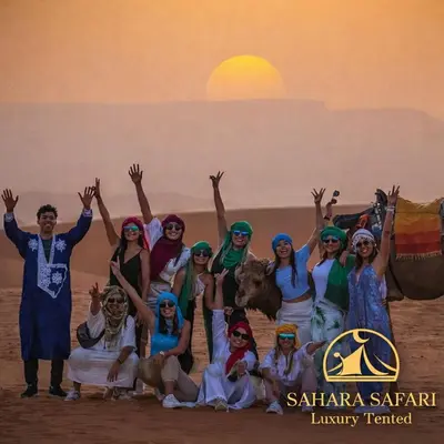 a group of people posing for a picture in the desert at Sahara Safari Luxury Tented in Merzouga