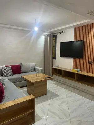 a living room with a couch and a flat screen tv at Cures & détente Appartement moderne Université EUROMED in Fès