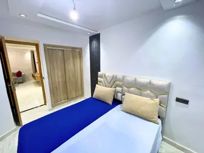a room with a blue couch and a window at Cures & détente Appartement moderne Université EUROMED in Fès