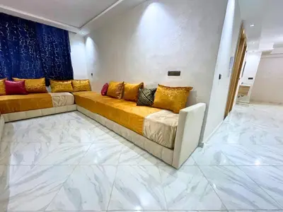 a living room with a couch with colorful pillows at Cures & détente Appartement moderne Université EUROMED in Fès