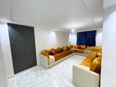 a living room with a couch and a table at Cures & détente Appartement moderne Université EUROMED in Fès