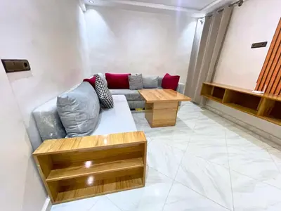 a living room with a couch and a table at Cures & détente Appartement moderne Université EUROMED in Fès