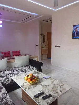 a living room with a couch and a bowl of fruit on a table at Premium comfort Appartemment lumineux proche médina in Fès