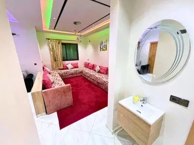 a living room with a couch and a mirror at Premium comfort Appartemment lumineux proche médina in Fès