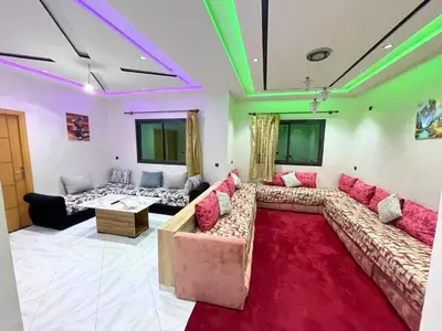 a living room with a couch and a red rug at Premium comfort Appartemment lumineux proche médina in Fès