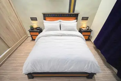 a bedroom with a large white bed with two night stands at Premium comfort Appartemment lumineux proche médina in Fès