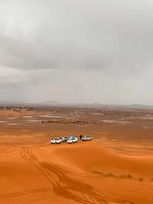 a group of cars parked in the desert at Berber Dreams Desert Camp in Merzouga