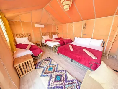 a room with two beds in a tent at Berber Dreams Desert Camp in Merzouga
