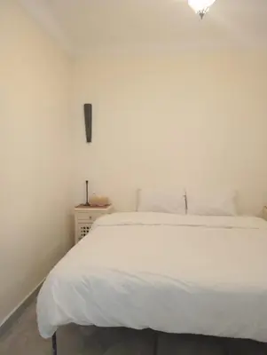 a bedroom with a white bed and a lamp at Dar Tissila in Marrakech