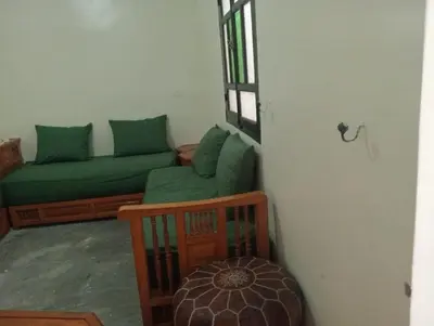 a living room with a green couch and a window at Dar Tissila in Marrakech