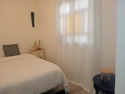 a bedroom with a white bed and a window at Dar Tissila in Marrakech