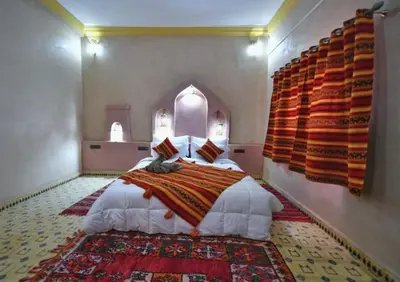 a bedroom with a large bed in a room at Riad Ali El Cojo in Hassilabied