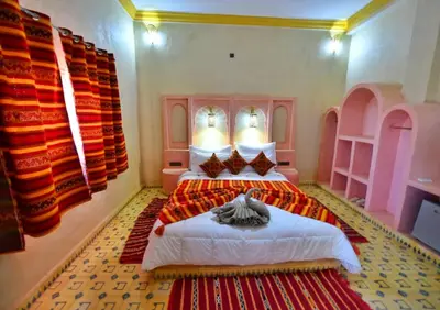 a bedroom with a bed in a room at Riad Ali El Cojo in Hassilabied