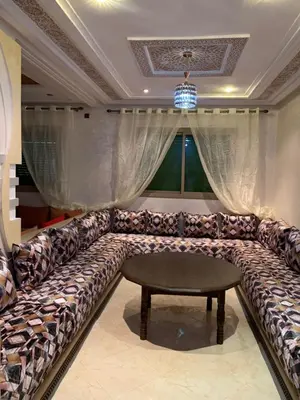 a large couch in a room with a table at Nice apartment in Fès