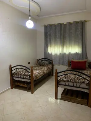 two beds in a room with a window at Nice apartment in Fès