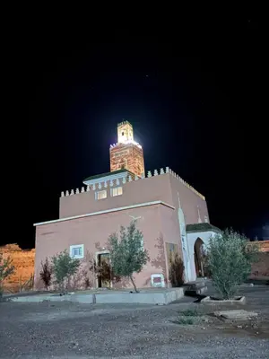 a building with a tower on top of it at night at Zaouit the officialle in Ouarzazate