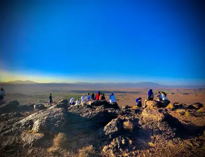 a group of people sitting on top of a mountain at Zaouit the officialle in Ouarzazate