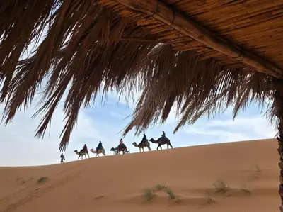 a group of people riding horses in the desert at Noor Dunes Camp in Merzouga