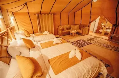 a room with three beds and a couch in a room at Merzouga Luxury Tented in Merzouga