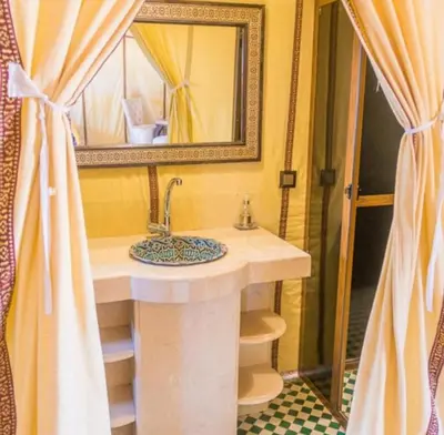 a bathroom with a sink and a mirror at Merzouga Luxury Tented in Merzouga