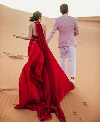 a man and a woman walking through the desert at Merzouga Luxury Tented in Merzouga