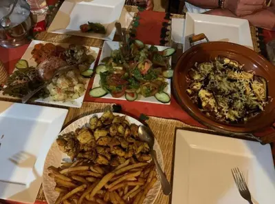 a table with plates of food and a bowl of food at Merzouga Luxury Tented in Merzouga