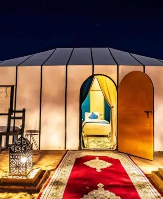 a room with a bed and a red carpet at Merzouga Luxury Tented in Merzouga