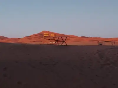 a picnic table in the middle of the desert at SAHARENA Camp in Merzouga