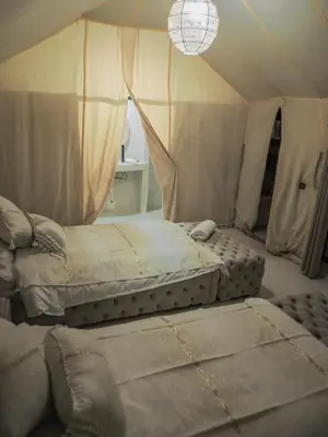 a bedroom with two beds in a tent at SAHARENA Camp in Merzouga